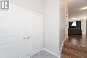 Ottawa townhouse for rent - A white door with a silver handle is in a room with wooden floors.