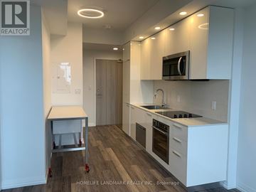 Toronto (Willowdale West) condo for rent - A kitchen with white cabinets and a wooden floor.