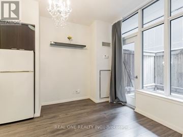 Toronto (Church-Yonge Corridor) condo for rent - A well-lit, spacious kitchen with a white refrigerator and a chandelier.