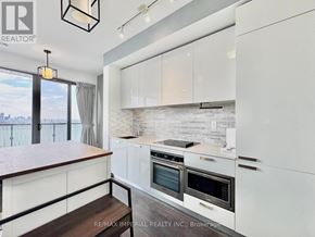 Toronto (Church-Yonge Corridor) condo for rent - A bedroom with a bed, a shelf with decorative items, and a balcony with a railing.