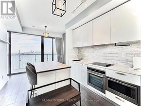 Toronto (Church-Yonge Corridor) condo for rent - A white dryer is stacked on top of a white washer in a small room.