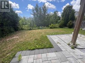 Markham (Box Grove) apartment for rent - A backyard with a paved walkway and a grassy area.