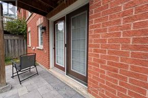 Markham (Box Grove) apartment for rent - A red brick house with a glass door and a black chair.