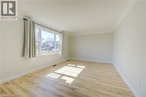Kitchener apartment for rent - A room with wooden flooring and a window with curtains.