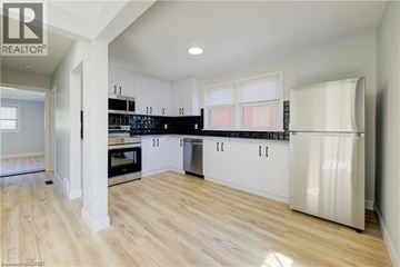 Kitchener apartment for rent - A kitchen with white cabinets and a wooden floor.