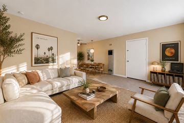 Monterey Park apartment for rent - A living room with a white sofa, a wooden coffee table, and a painting of palm trees.