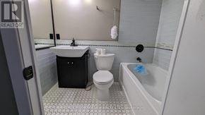 St. Catharines (Glendale/Glenridge) condo for rent - A bathroom with a white toilet, sink, and bathtub.