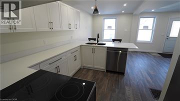 Hamilton apartment for rent - A modern kitchen with a stove top oven and a refrigerator.