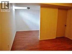 Calgary apartment for rent - A room with a wooden floor and a yellow door.