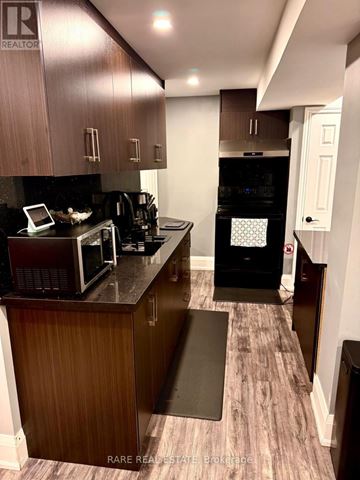 Brampton (Sandringham-Wellington) apartment for rent - A kitchen with a black oven and microwave.