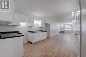 North Stormont fourplex for rent - A realtor photo of a white kitchen with wood floors.