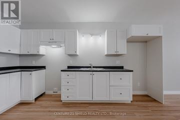 North Stormont fourplex for rent - A kitchen with white cabinets and black countertops.