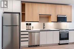 Lincoln (Beamsville) condo for rent - A modern kitchen with wooden cabinets and stainless steel appliances.