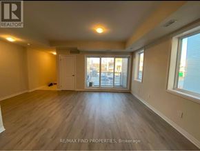 Kitchener townhouse for rent - A spacious room with wooden flooring and large windows.