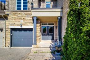 Oakville (Wm Westmount) townhouse for rent - A house with a stone facade and a blue garage door.