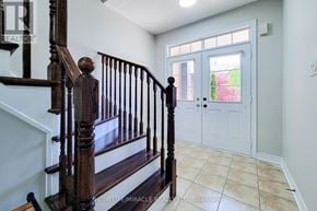 Oakville (Wm Westmount) townhouse for rent - A wooden staircase with a white wall and a door with a window.