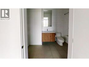 Burnaby apartment for rent - A bathroom with a toilet, sink and mirror.
