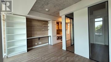 Toronto (The Beaches) condo for rent - A modern kitchen with white cabinets and a wooden backsplash.
