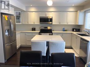 Georgian Bay (Baxter) house for rent - A kitchen with white cabinets and a refrigerator.
