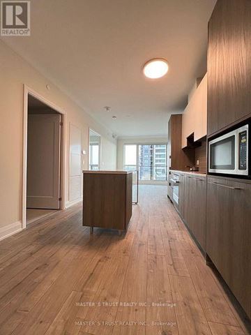 Markham (Unionville) condo for rent - A wood floored kitchen with a microwave on the counter.