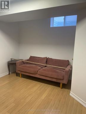 Richmond Hill (Crosby) apartment for rent - A brown couch sits in a room with wooden floors and white walls.