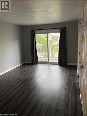 Brantford apartment for rent - A room with wooden flooring and a sliding glass door.
