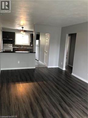 Brantford apartment for rent - A room with wooden floors and a window overlooking the kitchen.