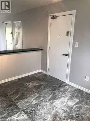 Brantford apartment for rent - A room with a marble floor and a white door.
