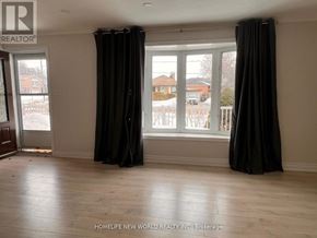 Bradford West Gwillimbury (Bradford) apartment for rent - A room with a large window and black curtains.