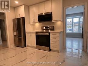 Bradford West Gwillimbury (Bradford) apartment for rent - A kitchen with white cabinets and a black microwave above the stove.