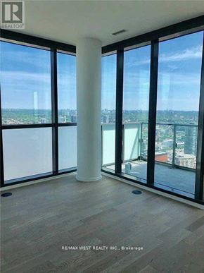 Toronto (Waterfront Communities) condo for rent - A room with a view of the cityscape through large windows.