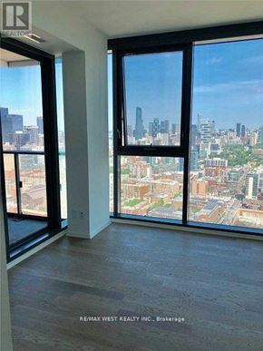 Toronto (Waterfront Communities) condo for rent - A room with a view of the city skyline through large windows.