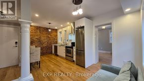 Ottawa multi-family for rent - A kitchen with a brick wall and wooden floors.
