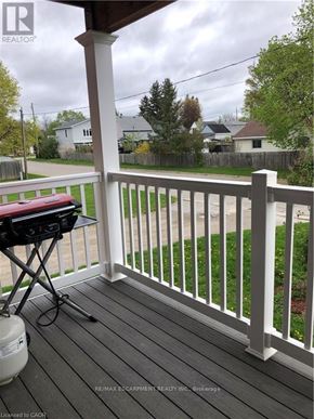 Brantford duplex for rent - A white railing on a wooden deck with a grill on it.