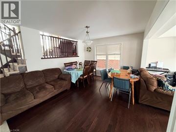 Kitchener apartment for rent - A living room with a brown couch and a dining table with chairs.