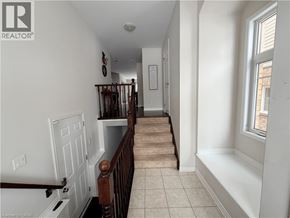 Kitchener apartment for rent - A hallway with a staircase and a framed document on the wall.