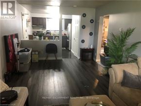 Brantford duplex for rent - A living room with a couch, a chair, and a potted plant.