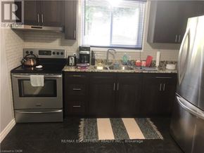 Brantford duplex for rent - A modern kitchen with a stainless steel refrigerator and a black stove top.