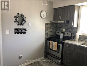 Brantford duplex for rent - A kitchen with a black oven and cabinets.