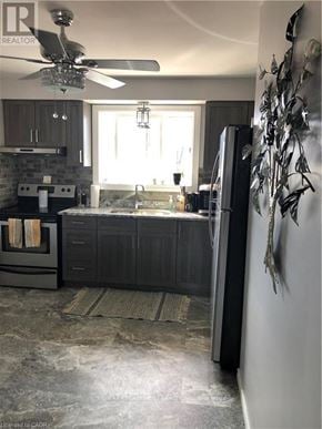 Brantford duplex for rent - A modern kitchen with a black refrigerator and a ceiling fan.