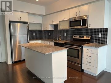 Toronto (Niagara) condo for rent - A kitchen with a stainless steel refrigerator and a granite countertop.