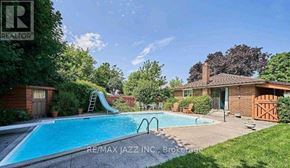 Oshawa (Donevan) apartment for rent - A swimming pool in a backyard with a slide and a house in the background.