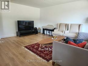 Oshawa (Donevan) apartment for rent - A living room with a couch, chair, and television.