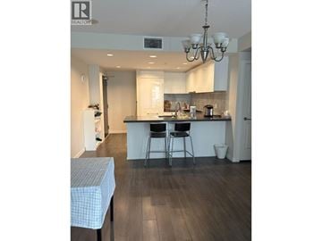 Richmond apartment for rent - A kitchen with a table and chairs in the foreground and a dining area in the background.
