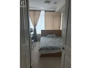 Richmond apartment for rent - A bedroom with a bed, chair, and window with curtains.