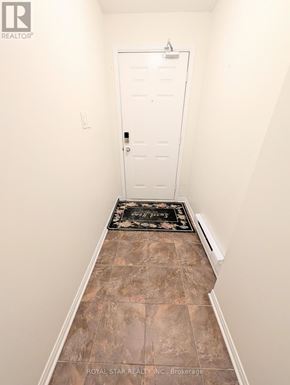 Ottawa condo for rent - A hallway with a white door and a brown rug.