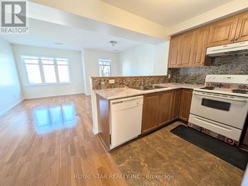 Ottawa condo for rent - A kitchen with wooden cabinets and a tiled backsplash.