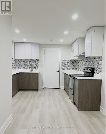 Markham (Raymerville) apartment for rent - A kitchen with white cabinets and a tiled backsplash.