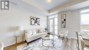 Milton (Cb Cobban) townhouse for rent - A living room with a white sofa, a coffee table, and a painting on the wall.