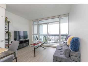 Surrey apartment for rent - A living room with a grey couch and a glass table.